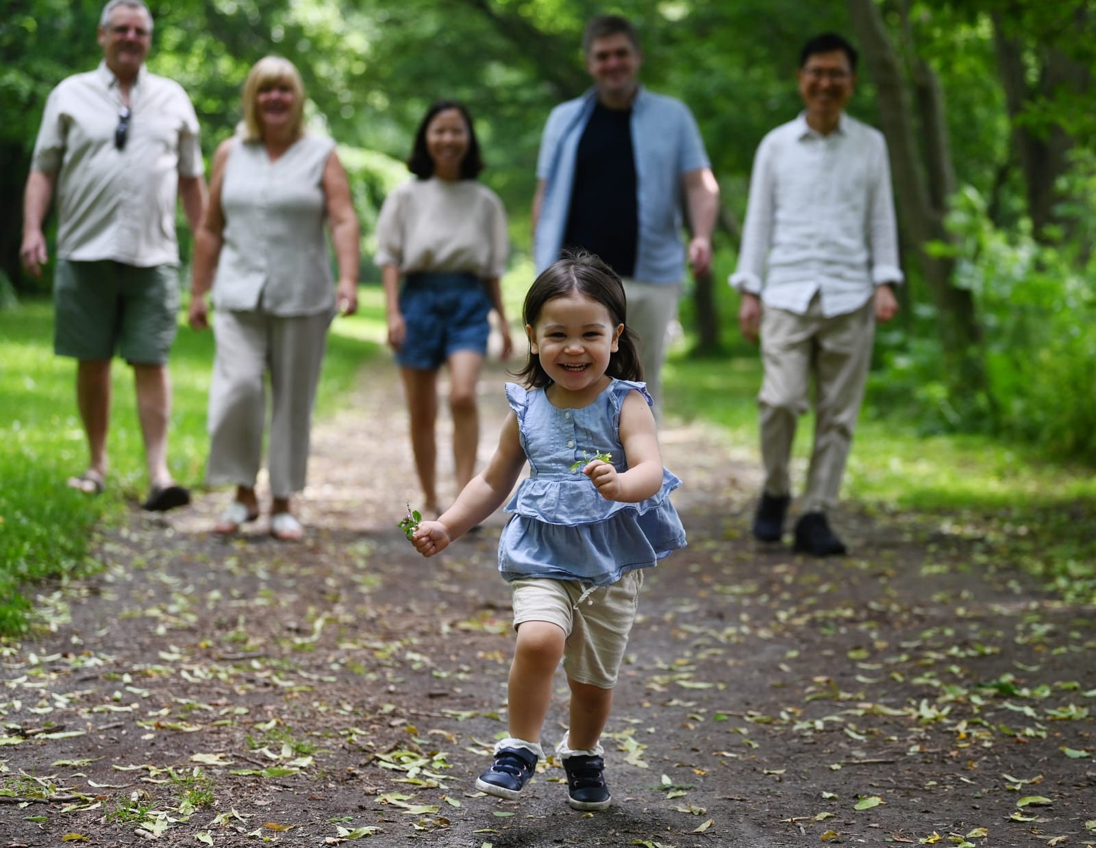 A family walking together on a wooded path